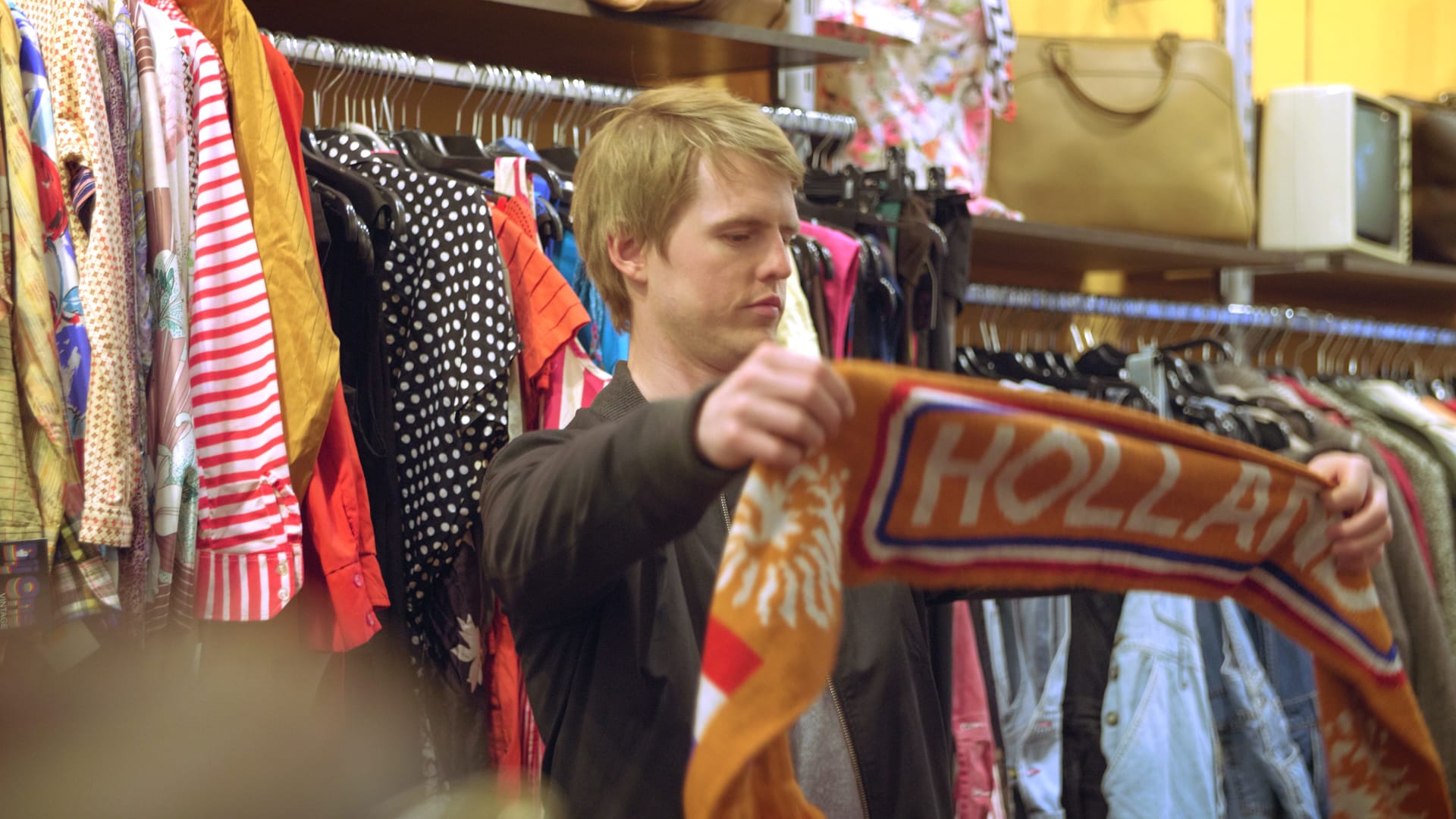 Man holding Dutch scarf in clothing store
